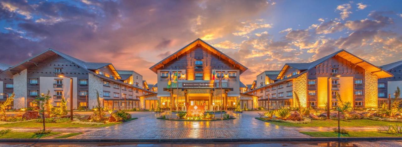 Wyndham Gramado Termas Resort & Spa Ngoại thất bức ảnh The photo shows a beautifully designed hotel or resort building. The architecture features a combination of modern and rustic elements, with a prominent sloping roof and wooden accents. The entrance is well lit, creating a welcoming atmosphere, espec